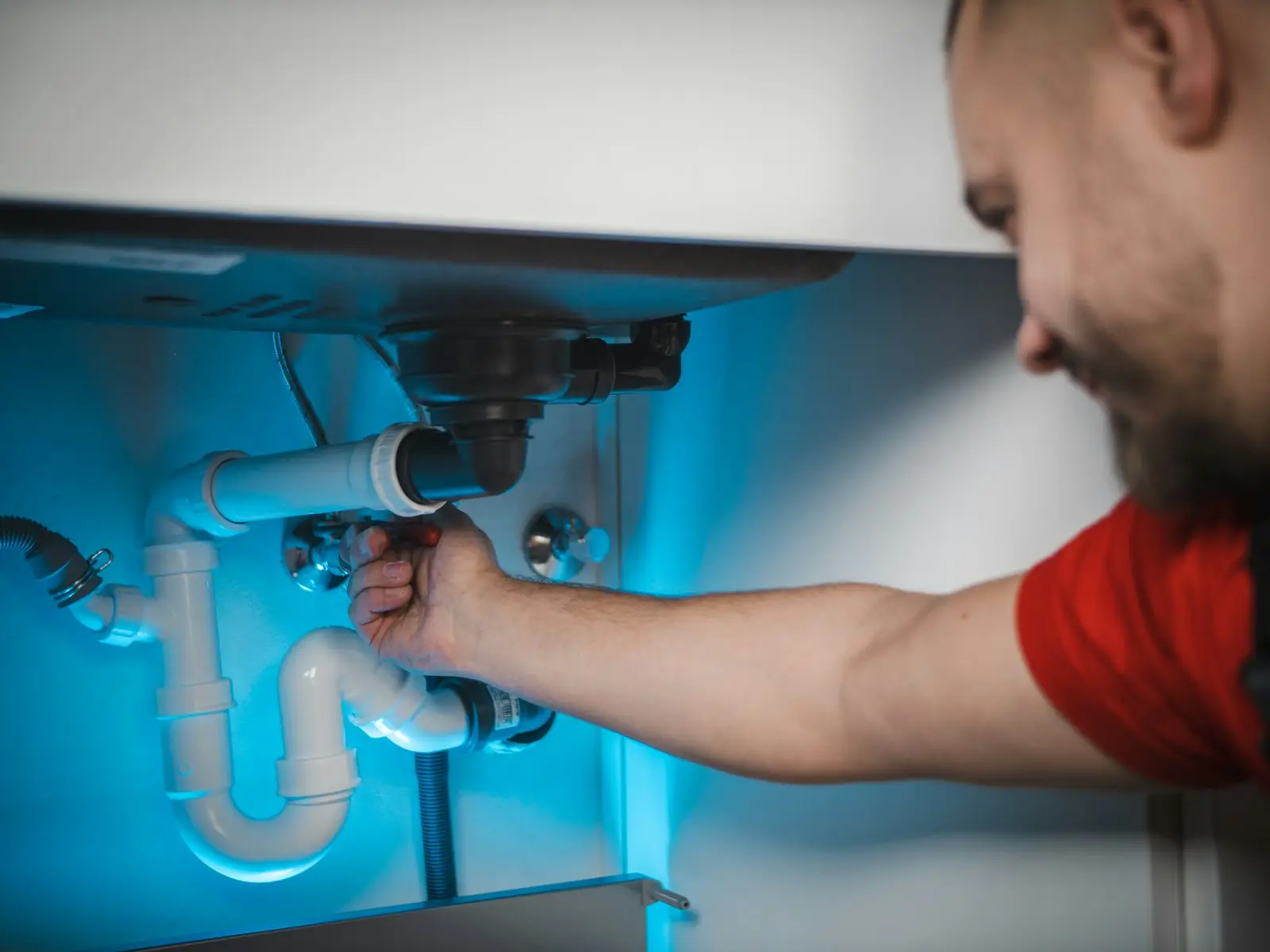 Monteur sluit een leiding aan in de muur
